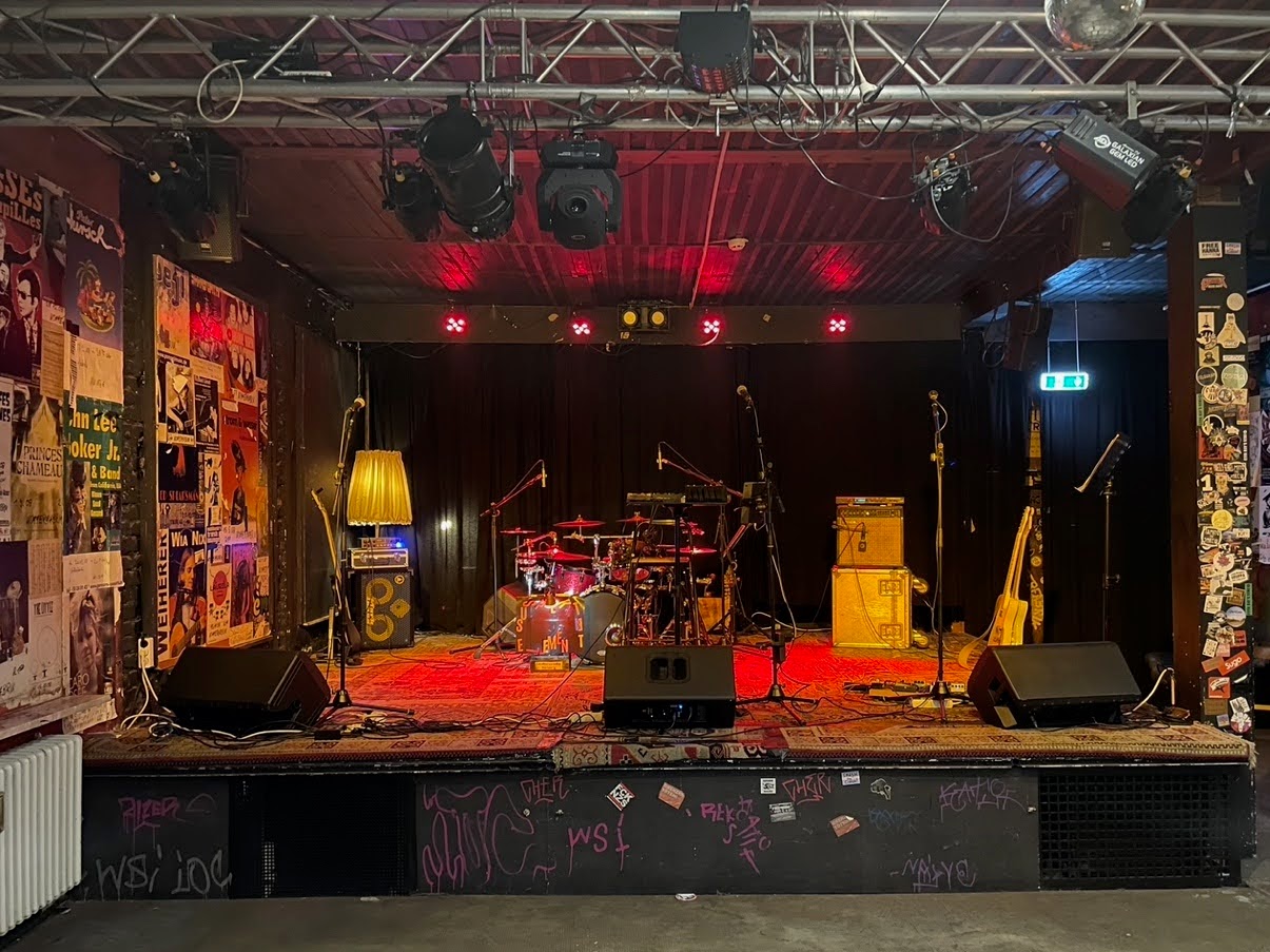 Bandfoto mit warmem Licht und rudimentärer Live-Atmosphaere.